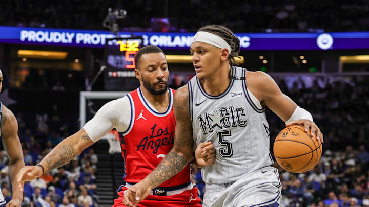 Mar 31, 2025; Orlando, Florida, USA; Orlando Magic forward Paolo Banchero (5) drives against LA Clippers guard Norman Powell (24) during the second quarter at Kia Center. Mandatory Credit: Mike Watters-Imagn Images