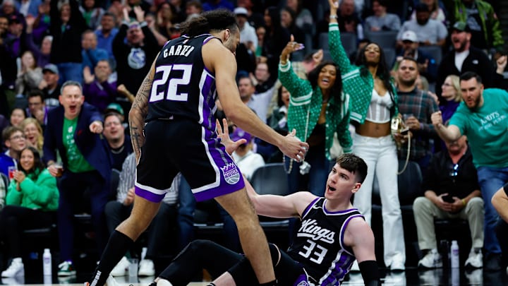 Mar 17, 2025; Sacramento, California, USA; Sacramento Kings forward Jake LaRavia (33) is picked up by guard Devin Carter (22) after a basket during the second quarter at Golden 1 Center. Mandatory Credit: Sergio Estrada-Imagn Images