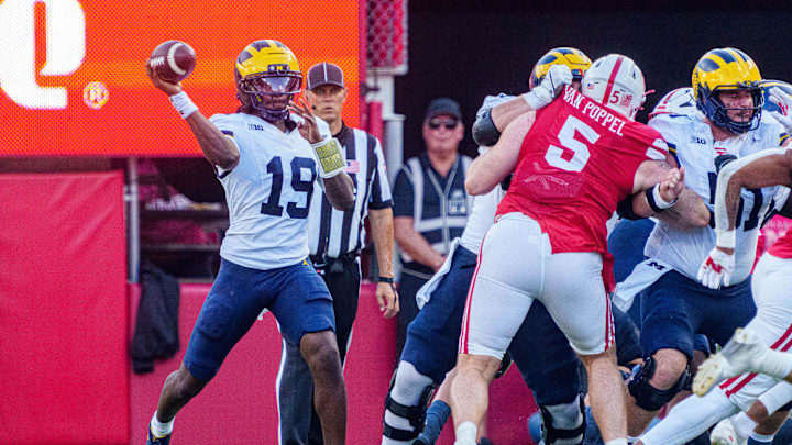 Sep 20, 2025; Lincoln, Nebraska, USA; Michigan Wolverines quarterback Bryce Underwood (19) passes against Nebraska Cornhuskers defensive lineman Riley Van Poppel (5) during the fourth quarter at Memorial Stadium. Mandatory Credit: Dylan Widger-Imagn Images