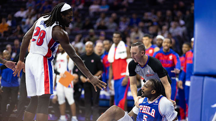 Oct 30, 2024; Philadelphia, Pennsylvania, USA; Detroit Pistons center Isaiah Stewart (28) extends his hand to Philadelphia 76ers center Andre Drummond (5) after knocking hm to the floor during the fourth quarter at Wells Fargo Center. Mandatory Credit: Bill Streicher-Imagn Images