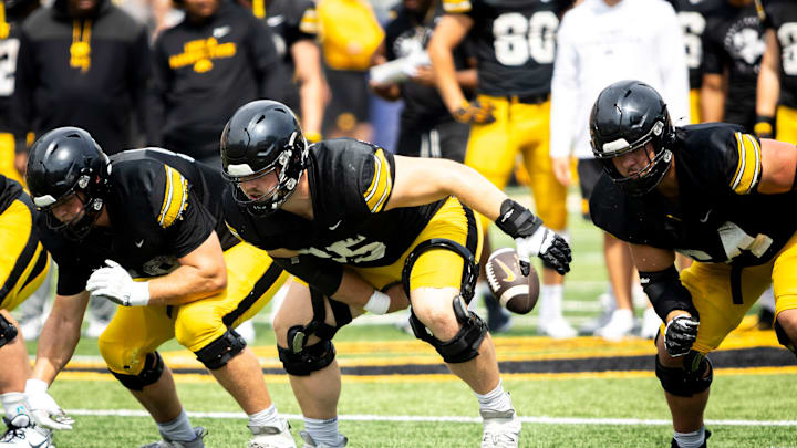 Aug 9, 2025; Iowa offensive lineman Logan Jones (65) snaps the ball during the Hawkeyes Kids Day NCAA football open practice at Kinnick Stadium in Iowa City, Iowa. Mandatory Credit: Joseph Cress for the Des Moines Register
