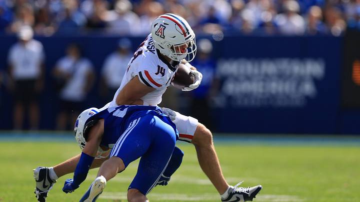 Sep 12, 2026; Provo, Utah, USA;  Arizona Wildcats tight end Cole Rusk (14) is tackled by BYU Cougars safety Tommy Prassas (22) during the second quarter at LaVell Edwards Stadium.