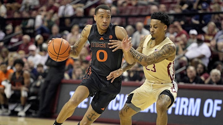 Mar 9, 2024; Tallahassee, Florida, USA; Miami Hurricanes guard Matthew Cleveland (0) drives the ball to the net against Florida State Seminoles guard Primo Spears (23) during the first half at Donald L. Tucker Center. 