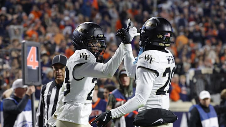 Nov 8, 2025; Charlottesville, Virginia, USA; Wake Forest Demon Deacons cornerback Braylon Johnson (23) celebrates with Demon Deacons safety Lardarius Webb Jr. (20) after blocking a touchdown pass during the final seconds of the second half against the Virginia Cavaliers at Scott Stadium. Mandatory Credit: Amber Searls-Imagn Images