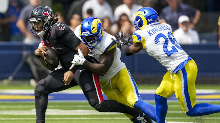 Sep 7, 2025; Inglewood, California, USA; Houston Texans quarterback C.J. Stroud (7) attempts to escape a tackle by Los Angeles Rams safety Kamren Kinchens (26) during the second quarter at SoFi Stadium. Mandatory Credit: Kirby Lee-Imagn Images