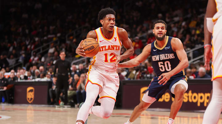 Dec 2, 2024; Atlanta, Georgia, USA; Atlanta Hawks forward De'Andre Hunter (12) drives on New Orleans Pelicans forward Jeremiah Robinson-Earl (50) in the second quarter at State Farm Arena. Mandatory Credit: Brett Davis-Imagn Images