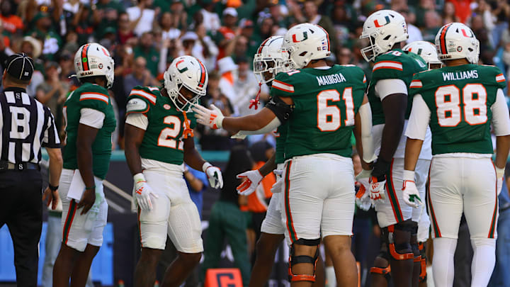 Nov 23, 2024; Miami Gardens, Florida, USA; Miami Hurricanes running back Jordan Lyle (21) celebrates with teammates after scoring a touchdown against the Wake Forest Demon Deacons during the fourth quarter at Hard Rock Stadium. Mandatory Credit: Sam Navarro-Imagn Images Nov 23, 2024; Miami Gardens, Florida, USA; Miami Hurricanes running back Jordan Lyle (21) celebrates with teammates after scoring a touchdown against the Wake Forest Demon Deacons during the fourth quarter at Hard Rock Stadium. Mandatory Credit: Sam Navarro-Imagn Images