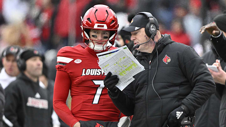 Louisville Cardinals head coach Jeff Brohm talks with quarterback Miller Moss (7) during the second half against Kentucky