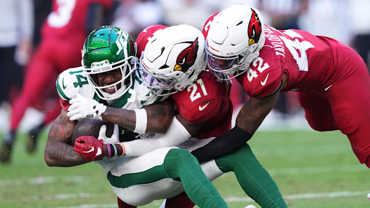 Nov 10, 2024; Glendale, Arizona, USA; Arizona Cardinals safety Dadrion Taylor-Demerson (42) and Arizona Cardinals cornerback Garrett Williams (21) tackle New York Jets wide receiver Malachi Corley (14) during the first half at State Farm Stadium. Mandatory Credit: Joe Camporeale-Imagn Images