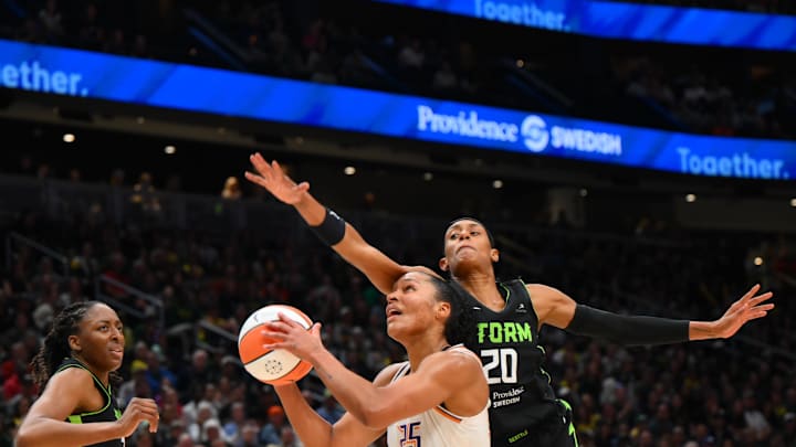 Aug 17, 2025; Seattle, Washington, USA; Phoenix Mercury forward Alyssa Thomas (25) is fouled by Seattle Storm guard Brittney Sykes (20) during the first half at Climate Pledge Arena. Mandatory Credit: Steven Bisig-Imagn Images