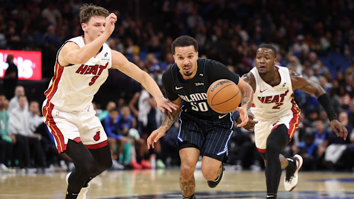 Dec 21, 2024; Orlando, Florida, USA; Orlando Magic guard Cole Anthony (50) controls a loose ball from Miami Heat guard Pelle Larsson (9) and guard Terry Rozier (2) in the third quarter at Kia Center. Mandatory Credit: Nathan Ray Seebeck-Imagn Images