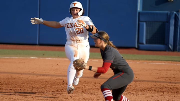Texas' Katie Stewart (20) leaps to second as Stanford infielder River Mahler (1) waits for the ball in the fourth inning of during a Women's College World Series semifinal softball game between the Stanford Cardinal and the Texas Longhorns at Devon Park in Oklahoma City, Monday, June 3, 2024. Texas won 1-0.