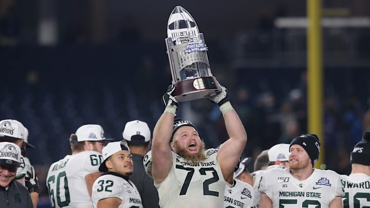 Dec 27, 2019; Bronx, New York, USA; Michigan State defensive tackle Mike Panasiuk (72) celebrates with the trophy after defeating the Wake Forest Demon Deacons in the Pinstripe Bowl at Yankee Stadium. Mandatory Credit: Brad Penner-Imagn Images