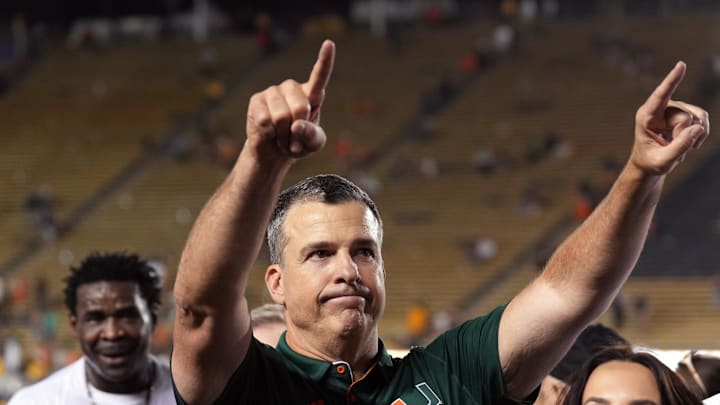 Oct 5, 2024; Berkeley, California, USA; Miami Hurricanes head coach Mario Cristobal (center left) gestures to fans with wife Jessica (center right) after defeating the California Golden Bears at California Memorial Stadium. Mandatory Credit: Darren Yamashita-Imagn Images