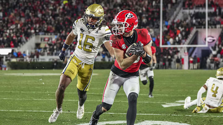 Nov 29, 2024; Athens, Georgia, USA; Georgia Bulldogs wide receiver London Humphreys (16) scores a touchdown behind Georgia Tech Yellow Jackets defensive back Syeed Gibbs (16) during overtime at Sanford Stadium. Mandatory Credit: Dale Zanine-Imagn Images