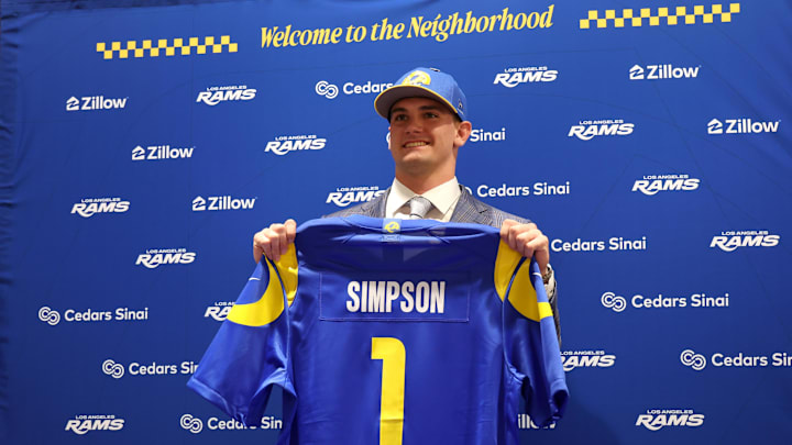 Rams first-round draft pick Ty Simpson poses with his jersey during a press conference.