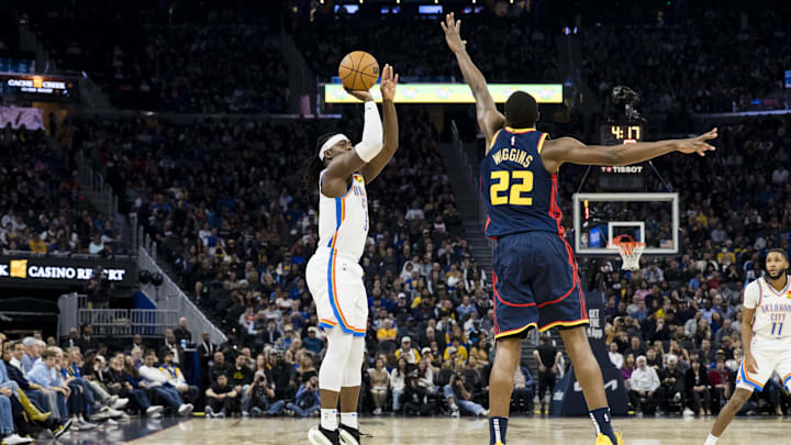 Nov 27, 2024; San Francisco, California, USA; Oklahoma City Thunder guard Luguentz Dort (5) takes a three-point shot as Golden State Warriors forward Andrew Wiggins (22) defends during the first half at Chase Center. Mandatory Credit: John Hefti-Imagn Images