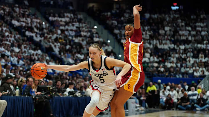 Dec 21, 2024; Hartford, Connecticut, USA; UConn Huskies guard Paige Bueckers (5) drives the ball against USC Trojans guard JuJu Watkins (12) in the first half at XL Center. Mandatory Credit: David Butler II-Imagn Images