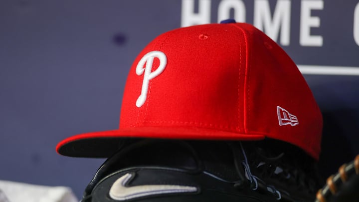 A detailed view of a Philadelphia Phillies hat and glove on the bench against the Atlanta Braves in the seventh inning at Truist Park on May 26.
