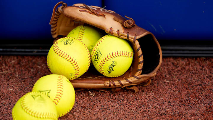 A softball glove with softballs is pictured before Game 1 of the Women's College World Series championship series between the Texas Longhorns at Texas Tech Red Raiders at Devon Park in Oklahoma City, Wednesday, June 4, 2025. Texas won 2-1.