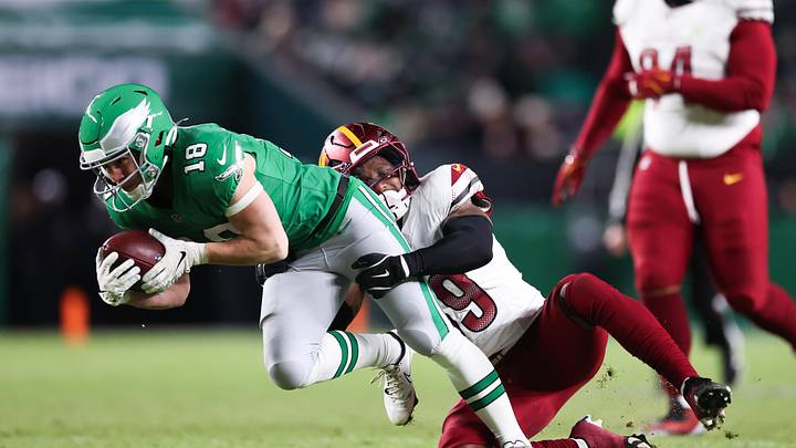 Jan 4, 2026; Philadelphia, Pennsylvania, USA;  Philadelphia Eagles wide receiver Britain Covey (18) runs after making a catch as Washington Commanders safety Jeremy Reaves (39) tackles during the third quarter at Lincoln Financial Field. 