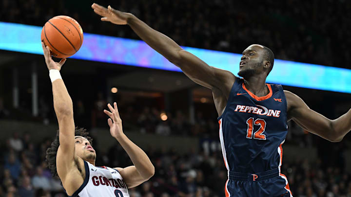 Jan 4, 2024; Spokane, Washington, USA; Gonzaga Bulldogs guard Ryan Nembhard (0) shoots the ball against Pepperdine Waves forward Boubacar Coulibaly (12) in the first half at Spokane Arena. Mandatory Credit: James Snook-Imagn Images