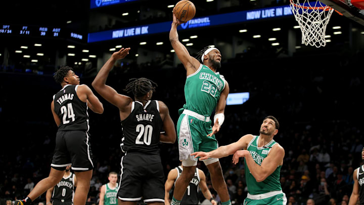 Feb 8, 2022; Brooklyn, New York, USA; Boston Celtics forward Bruno Fernando (28) dunks against Brooklyn Nets guard Cam Thomas (24) and center Day'Ron Sharpe (20) during the fourth quarter at Barclays Center. Mandatory Credit: Brad Penner-Imagn Images