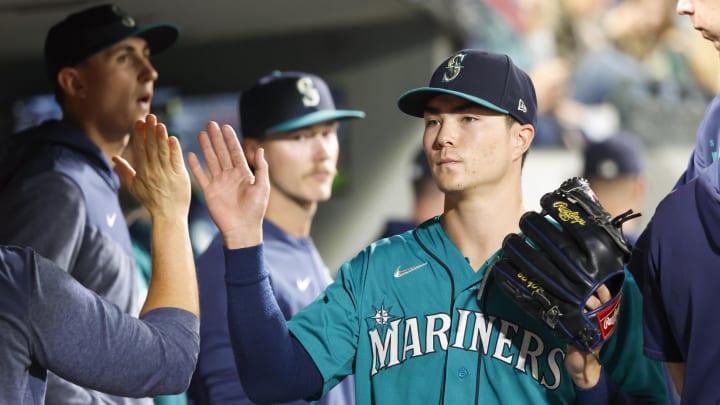 Sep 12, 2023; Seattle, Washington, USA; Seattle Mariners starting pitcher Bryan Woo (33) high-fives teammates and staff in the dugout during a sixth inning pitching change against the Los Angeles Angels at T-Mobile Park in 2023.