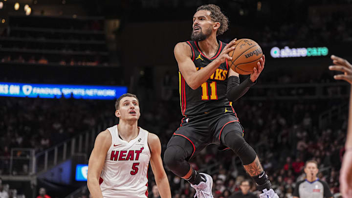 Dec 28, 2024; Atlanta, Georgia, USA; Atlanta Hawks guard Trae Young (11) looks to pass behind Miami Heat forward Nikola Jovic (5) at State Farm Arena. Mandatory Credit: Dale Zanine-Imagn Images