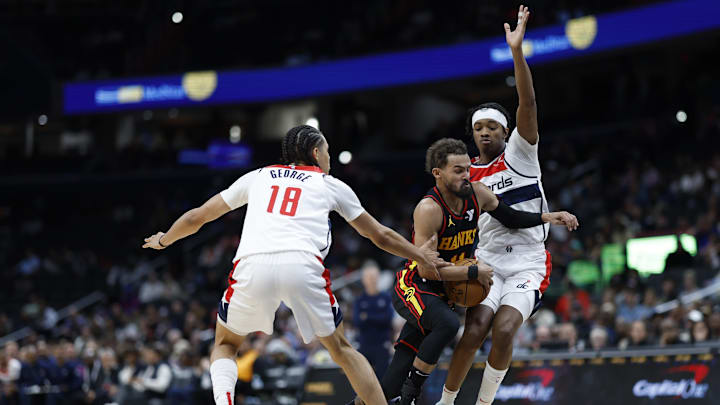 Oct 30, 2024; Washington, District of Columbia, USA; Atlanta Hawks guard Trae Young (11) drives to the basket as Washington Wizards forward Kyshawn George (18) and Wizards guard Bilal Coulibaly (0) defend in the first half at Capital One Arena. Mandatory Credit: Geoff Burke-Imagn Images