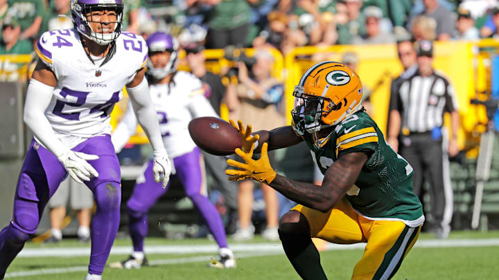 Green Bay Packers wide receiver Dontayvion Wicks (13) scores a touchdown in the fourth quarter against Minnesota Vikings safety Camryn Bynum (24) during their football game Sunday, September 29, 2024, at Lambeau Field in Green Bay, Wisconsin.