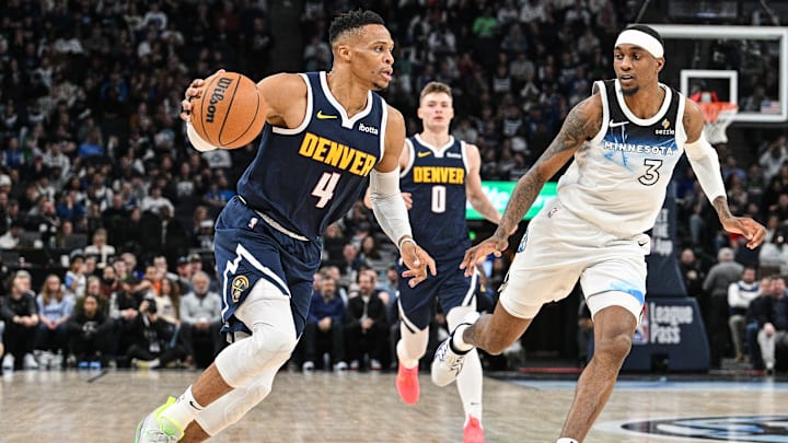 Jan 25, 2025; Minneapolis, Minnesota, USA; Denver Nuggets guard Russell Westbrook (4) dribbles past Minnesota Timberwolves forward Jaden McDaniels (3) during the second quarter at Target Center. Mandatory Credit: Jeffrey Becker-Imagn Images