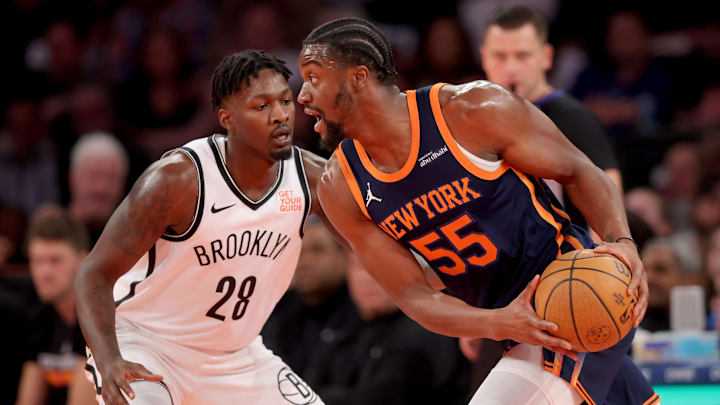 New York Knicks center Ariel Hukporti controls the ball against Brooklyn Nets forward Dorian Finney-Smith. Mandatory Credit: Brad Penner-Imagn Images