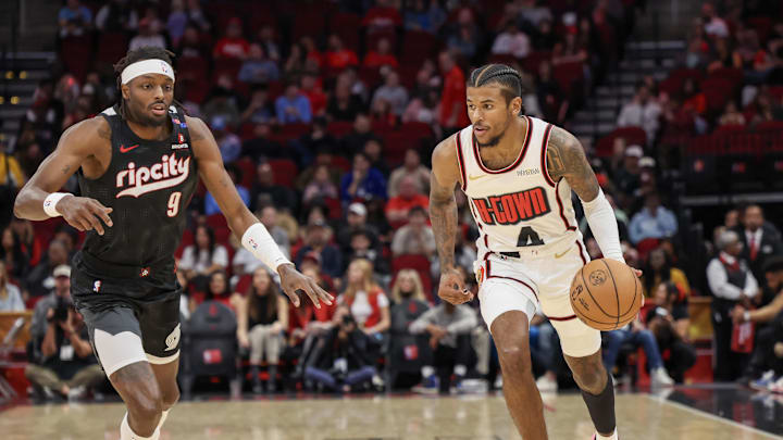 Nov 23, 2024; Houston, Texas, USA;  Houston Rockets guard Jalen Green (4) dribbles against Portland Trail Blazers forward Jerami Grant (9) in the first quarter at Toyota Center. Mandatory Credit: Thomas Shea-Imagn Images