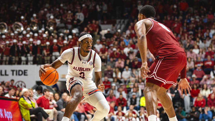 Feb 15, 2025; Tuscaloosa, Alabama, USA; Auburn Tigers guard Denver Jones (2) dribbles the ball against Alabama Crimson Tide guard Chris Youngblood (8) during the first half at Coleman Coliseum. Mandatory Credit: Will McLelland-Imagn Images