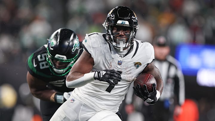 Dec 22, 2022; East Rutherford, New Jersey, USA; Jacksonville Jaguars RB Travis Etienne Jr. (1) and New York Jets DE Carl Lawson (58) at MetLife Stadium. Mandatory Credit: Vincent Carchietta-USA TODAY Sports