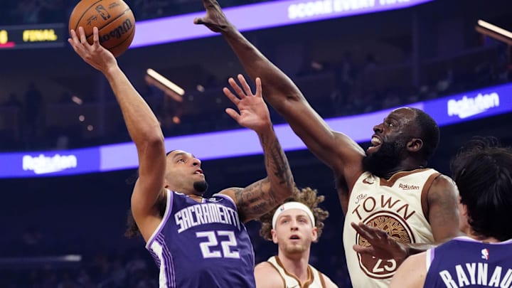 Apr 7, 2026; San Francisco, California, USA;  Sacramento Kings guard Devin Carter (22) shoots over Golden State Warriors forward Draymond Green (23) and guard Brandin Podziemski (2) in the first quarter at Chase Center. Mandatory Credit: David Gonzales-Imagn Images
