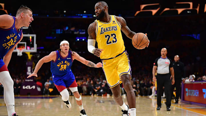 Apr 25, 2024; Los Angeles, California, USA; Los Angeles Lakers forward LeBron James (23) moves the ball against Denver Nuggets center Nikola Jokic (15) and forward Aaron Gordon (50) during the second half in game three of the first round for the 2024 NBA playoffs at Crypto.com Arena. Mandatory Credit: Gary A. Vasquez-Imagn Images