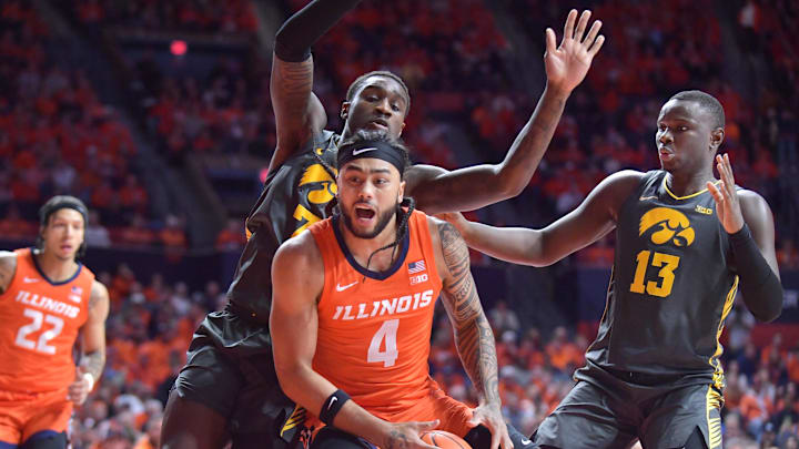 Feb 25, 2025; Champaign, Illinois, USA;  Illinois Fighting Illini guard Kylan Boswell (4) drives to the basket as Iowa Hawkeyes forward Seydou Traore (7) pressures during the first half at State Farm Center. Mandatory Credit: Ron Johnson-Imagn Images