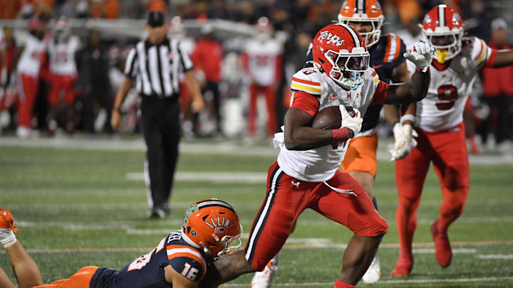 Nov 15, 2025; Champaign, Illinois, USA; Maryland Terrapins running back DeJuan Williams (0) drags defender Illinois Fighting Illini defensive back Tanner Heckel (16) during the second half at Memorial Stadium. Mandatory Credit: Ron Johnson-Imagn Images