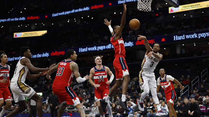 Jan 5, 2025; Washington, District of Columbia, USA; New Orleans Pelicans guard CJ McCollum (3) leaps to pass the ball as Washington Wizards forward Alexandre Sarr (20) defends in the fourth quarter at Capital One Arena. Mandatory Credit: Geoff Burke-Imagn Images