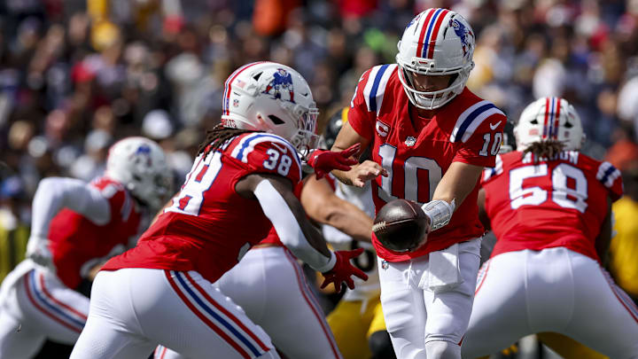 Sep 21, 2025; Foxborough, Massachusetts, USA; New England Patriots quarterback Drake Maye (10) hands off the ball to New England Patriots running back Rhamondre Stevenson (38) during the first quarter at Gillette Stadium. Mandatory Credit: Paul Rutherford-Imagn Images