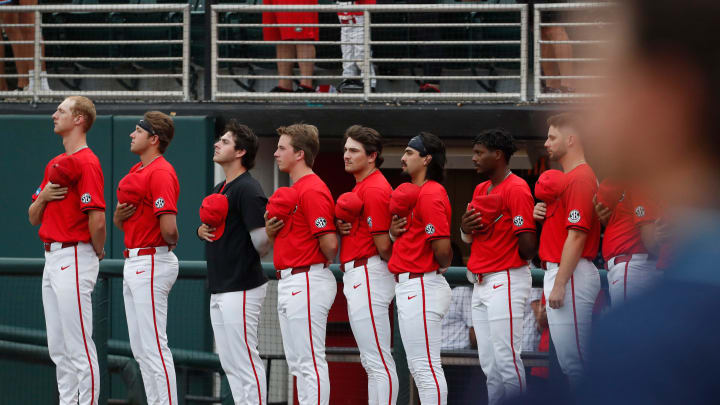 Georgia players remove their hats during the national anthem before the start of a NCAA Athens Regional baseball game against UNCW in Athens, Ga., on Saturday, June 1, 2024. Georgia won 11-2.