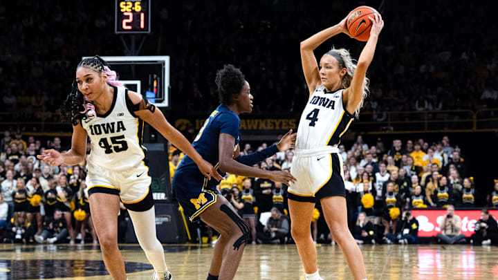 Iowa guard Kylie Feuerbach (4) looks to pass the basketball as Iowa forward Hannah Stuelke (45) feigns a screen Feb. 22, 2026 at Carver-Hawkeye Arena in Iowa City, Iowa.
