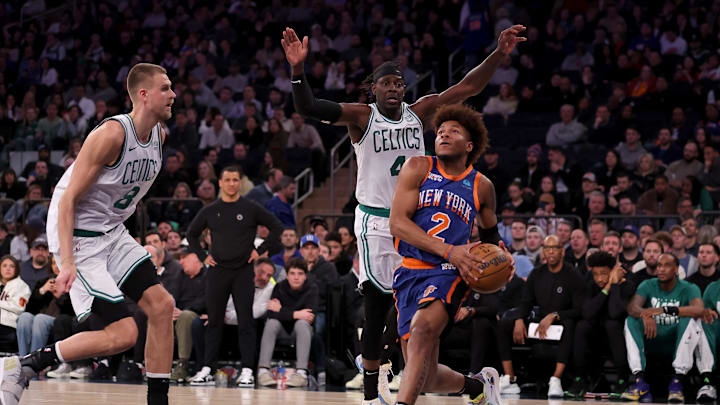 Feb 24, 2024; New York, New York, USA; New York Knicks guard Miles McBride (2) drives to the basket against Boston Celtics center Kristaps Porzingis (8) and guard Jrue Holiday (4) during the fourth quarter at Madison Square Garden. Mandatory Credit: Brad Penner-Imagn Images
