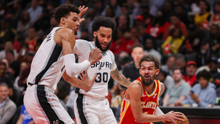 Feb 5, 2025; Atlanta, Georgia, USA; Atlanta Hawks guard Trae Young (11) is defended by San Antonio Spurs center Victor Wembanyama (1) and forward Julian Champagnie (30) in the second quarter at State Farm Arena. Mandatory Credit: Brett Davis-Imagn Images
Feb 5, 2025; Atlanta, Georgia, USA; Atlanta Hawks guard Trae Young (11) is defended by San Antonio Spurs center Victor Wembanyama (1) and forward Julian Champagnie (30) in the second quarter at State Farm Arena. Mandatory Credit: Brett Davis-Imagn Images