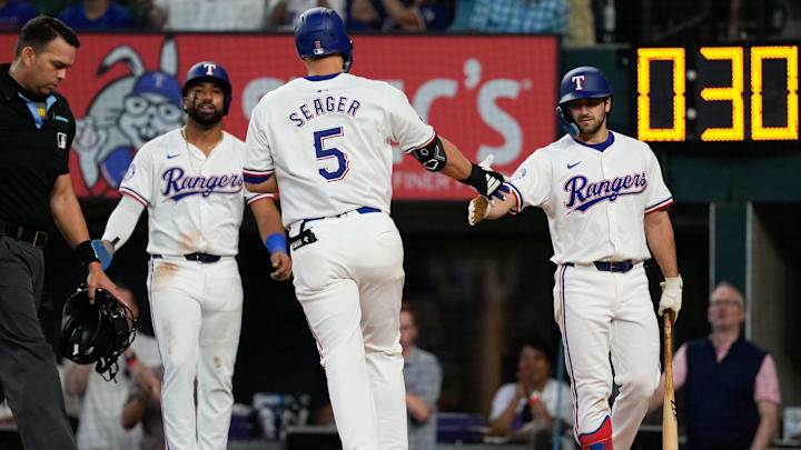 May 29, 2024; Arlington, Texas, USA;  Texas Rangers shortstop Corey Seager (5) celebrates his two-run home run with third baseman Josh Smith (right) and center fielder Leody Taveras (left) against the Arizona Diamondbacks during the fifth inning at Globe Life Field. Mandatory Credit: Jim Cowsert-USA TODAY Sports
