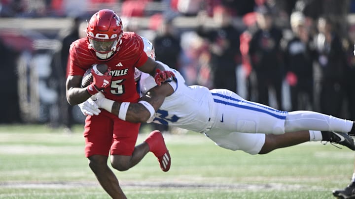 Nov 25, 2023; Louisville, Kentucky, USA;  Louisville Cardinals running back Jawhar Jordan (25) runs the ball against Kentucky Wildcats linebacker Trevin Wallace (32) during the first quarter at L&N Federal Credit Union Stadium. Mandatory Credit: Jamie Rhodes-Imagn Images