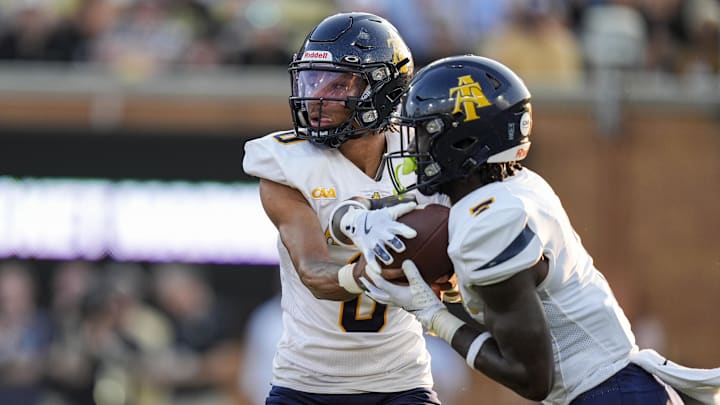 Aug 29, 2024; Winston-Salem, North Carolina, USA; North Carolina A&T Aggies quarterback Kevin White (0) hands off to running back Kenji Christian (7) during the first half against the Wake Forest Demon Deacons at Allegacy Federal Credit Union Stadium. Mandatory Credit: Jim Dedmon-Imagn Images Aug 29, 2024; Winston-Salem, North Carolina, USA; North Carolina A&T Aggies quarterback Kevin White (0) hands off to running back Kenji Christian (7) during the first half against the Wake Forest Demon Deacons at Allegacy Federal Credit Union Stadium. Mandatory Credit: Jim Dedmon-Imagn Images