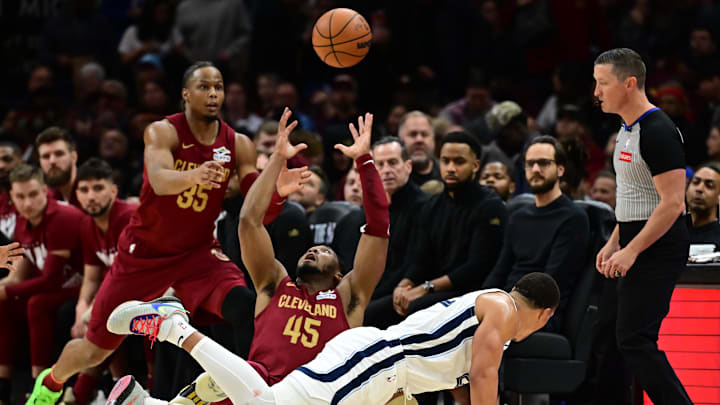 Feb 23, 2025; Cleveland, Ohio, USA; Cleveland Cavaliers guard Donovan Mitchell (45) goes for a loose ball as forward Isaac Okoro (35) looks on during the second half at Rocket Arena. Mandatory Credit: Ken Blaze-Imagn Images